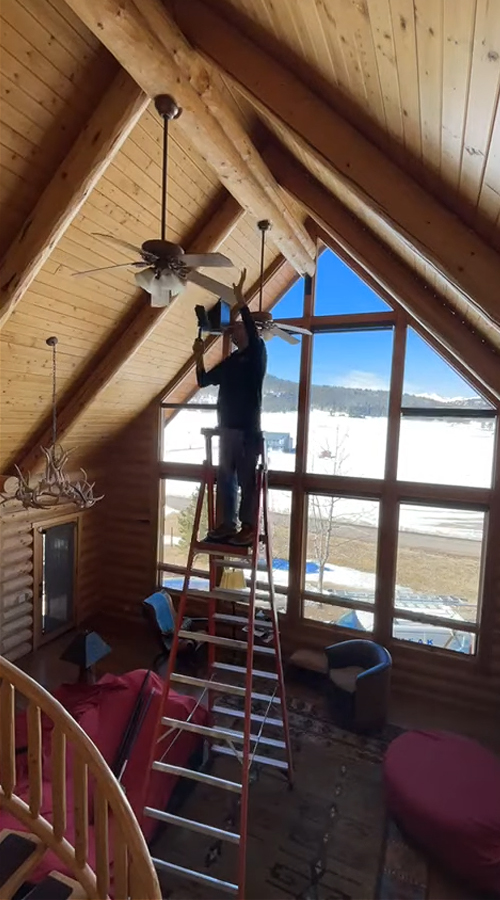 Photo: the PEAK team cleaning high light fixtures and fans.